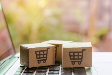İnternetten alışveriş, kağıt kutular ya da klavyede alışveriş arabası logosu olan bir paket. İnternet üzerinden alışveriş hizmeti sunuyor.