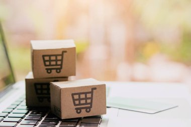 İnternetten alışveriş, kağıt kutular ya da klavyede alışveriş arabası logosu ve kredi kartı olan bir paket. İnternet üzerinden alışveriş hizmeti sunuyor..