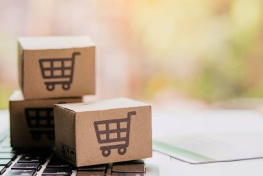İnternetten alışveriş, kağıt kutular ya da klavyede alışveriş arabası logosu ve kredi kartı olan bir paket. İnternet üzerinden alışveriş hizmeti sunuyor..