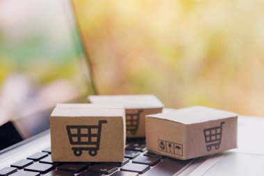 İnternetten alışveriş, kağıt kutular ya da klavyede alışveriş arabası logosu olan bir paket. İnternet üzerinden alışveriş hizmeti sunuyor.