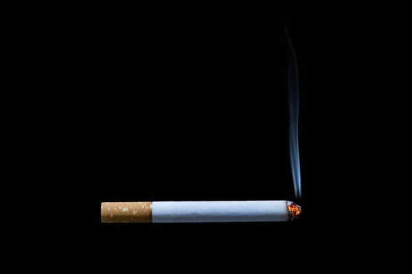 Cigarette burning isolated on black background — Stock Photo, Image