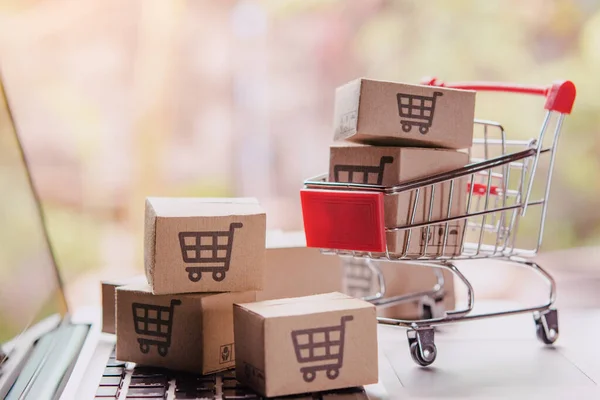 Shopping online concept - Parcel or Paper cartons with a shoppin — Stock Photo, Image
