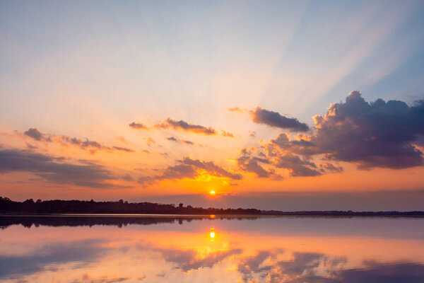 Sunset reflection lagoon. beautiful sunset behind the clouds and
