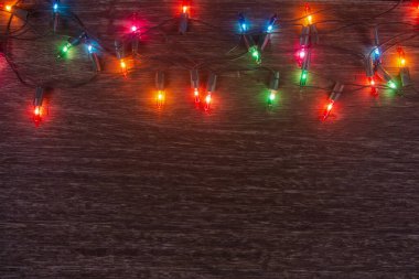 Karanlık ahşap arka planda Noel ışıkları. Mutlu Noeller. 