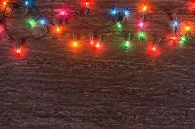Karanlık ahşap arka planda Noel ışıkları. Mutlu Noeller. 
