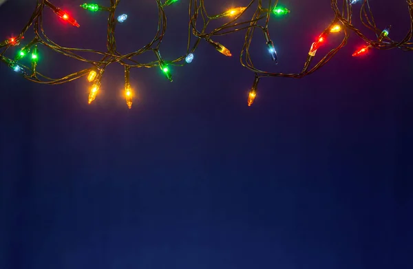 Vánoční osvětlení na modrém podkladu s kopií prostor — Stock fotografie