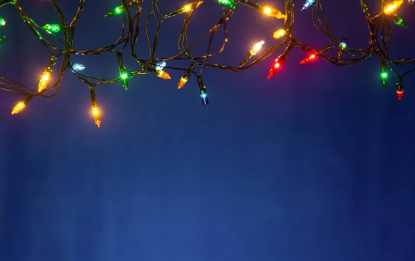 Vánoční osvětlení na modrém podkladu s kopií prostor — Stock fotografie