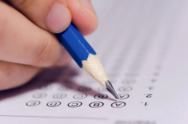 Studenti mano che tengono la scrittura a matita scelta selezionata sulla risposta s — Foto Stock