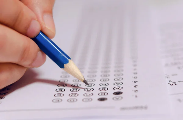 Estudiantes mano celebración lápiz escritura elección seleccionada en respuesta s — Foto de Stock