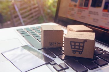 İnternetten alışveriş, kağıt kutular ya da klavyede alışveriş arabası logosu ve kredi kartı olan bir paket. İnternet üzerinden alışveriş hizmeti sunuyor.