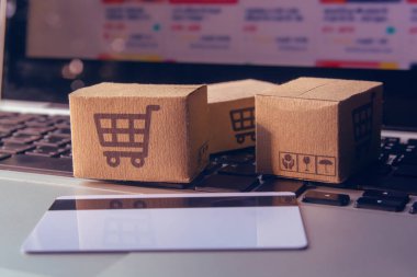 İnternetten alışveriş, kağıt kutular ya da klavyede alışveriş arabası logosu ve kredi kartı olan bir paket. İnternet üzerinden alışveriş hizmeti sunuyor.