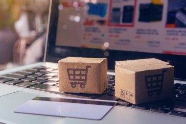 İnternetten alışveriş, kağıt kutular ya da klavyede alışveriş arabası logosu ve kredi kartı olan bir paket. İnternet üzerinden alışveriş hizmeti sunuyor.