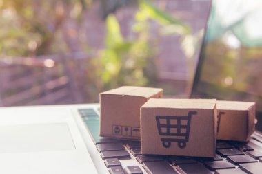 İnternetten alışveriş, kağıt kutular ya da klavyede alışveriş arabası logosu olan bir paket. İnternet üzerinden alışveriş hizmeti sunuyor.