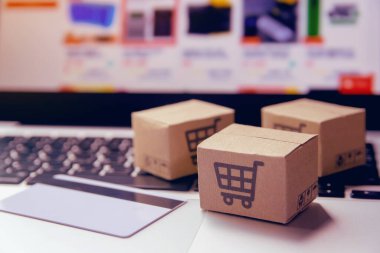 İnternetten alışveriş, kağıt kutular ya da klavyede alışveriş arabası logosu ve kredi kartı olan bir paket. İnternet üzerinden alışveriş hizmeti sunuyor.