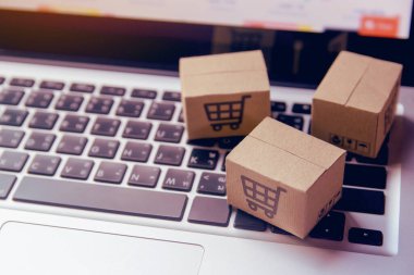 İnternetten alışveriş, kağıt kutular ya da klavyede alışveriş arabası logosu olan bir paket. İnternet üzerinden alışveriş hizmeti sunuyor.