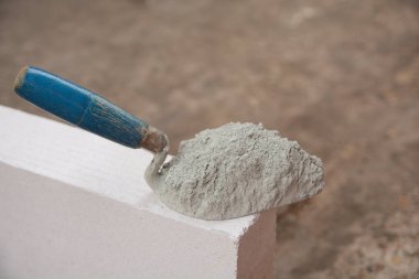 Çimento tozu ya da havan topuzu inşaat için hafif beton tuğla üzerine konur.