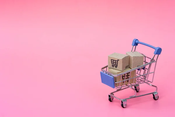 ショッピングのコンセプト ピンクの背景に青いショッピングカートのカートンまたはペーパーボックス オンラインショッピングの消費者は自宅や宅配サービスから買い物ができます Spacをコピーして — ストック写真