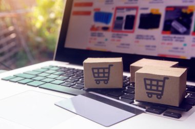 İnternetten alışveriş, kağıt kutular ya da klavyede alışveriş arabası logosu ve kredi kartı olan bir paket. İnternet üzerinden alışveriş hizmeti sunuyor.