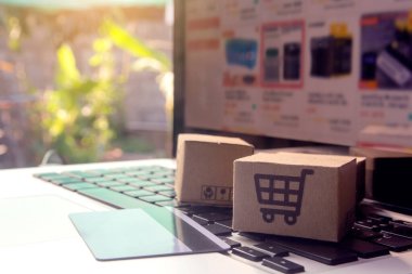 İnternetten alışveriş, kağıt kutular ya da klavyede alışveriş arabası logosu ve kredi kartı olan bir paket. İnternet üzerinden alışveriş hizmeti sunuyor.