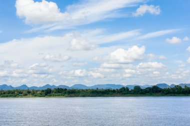 Nehir ve sirrus, kümülüs bulutları mavi gökyüzü arka planında.