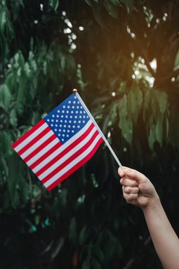 Yeşil ormanda ABD Bayrağı 'nı tutan kadın. 4 Temmuz Amerikan Bağımsızlık Günü