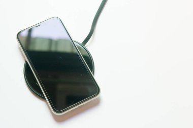 Akıllı telefon kablosuz şarj cihazına yükleniyor. 