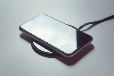 Akıllı telefon kablosuz şarj cihazına yükleniyor. 