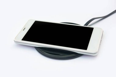 Beyaz arka planda kablosuz şarj cihazına akıllı telefon şarj oluyor. Kopyalama alanı için kırpma yolu olan siyah ekran veya boş ekran. Düz la