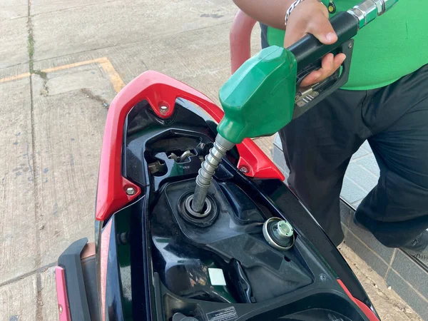 ガソリンスタンドでバイクに注ぐハンド燃料ノズル — ストック写真