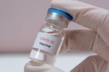 Aşı COVID-19 (Coronavirus) cam şişesi tıp doktoru elinde