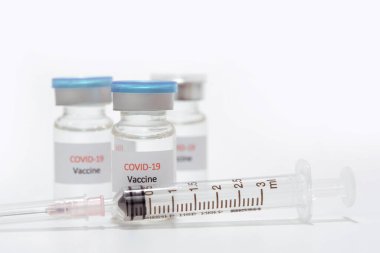 Aşı COVID-19 (Coronavirus) cam şişe ve beyaz şırınga üzerinde
