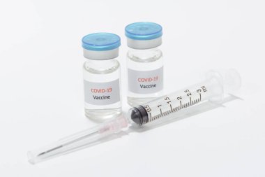Aşı COVID-19 (Coronavirus) cam şişe ve beyaz şırınga üzerinde