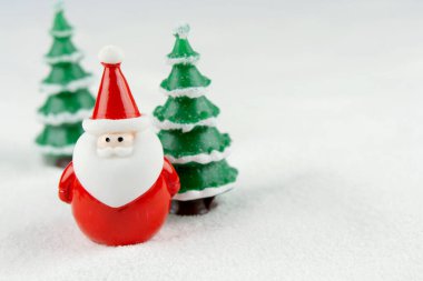 Mutlu Noeller ve mutlu yıllar konsepti. Tatlı noel baba figürü ve karlar üzerinde fotokopi alanı olan ağaç