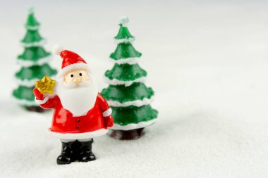 Mutlu Noeller ve mutlu yıllar konsepti. Tatlı noel baba figürü ve karlar üzerinde fotokopi alanı olan ağaç