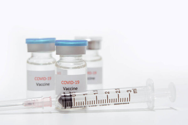 Vaccine COVID-19 (Coronavirus) in glass bottle and syringe on white