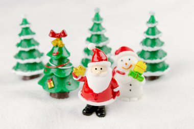 Mutlu Noeller ve mutlu yıllar konsepti. Şirin Noel Baba, kardan adam figürü ve kopyalanmış karlı ağaç.