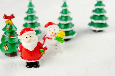 Mutlu Noeller ve mutlu yıllar konsepti. Şirin Noel Baba, kardan adam figürü ve kopyalanmış karlı ağaç.