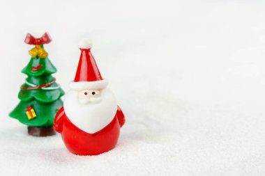 Mutlu Noeller ve mutlu yıllar konsepti. Tatlı noel baba figürü ve karlar üzerinde fotokopi alanı olan ağaç