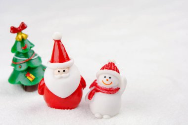 Mutlu Noeller ve mutlu yıllar konsepti. Şirin Noel Baba, kardan adam figürü ve kopyalanmış karlı ağaç.