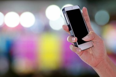 Bir boş ekran smartphone ve bulanık renkli bokeh arka plan ekran panelinde kırpma yoluyla kullanan adam