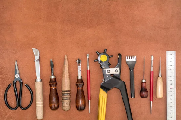 Tools for crafting and pieces of brown leather Layout about manufacture of goods — Stock Photo, Image