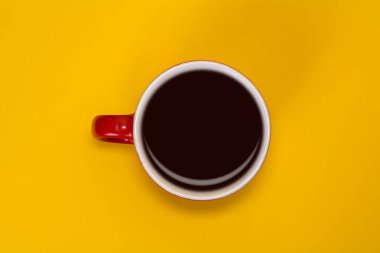 Kırmızı Kupası kahve üzerinde sarı bir arka plan ile. Yukarıdan görüntülemek
