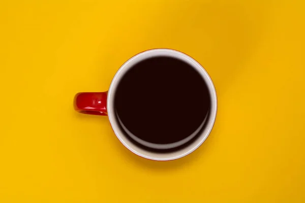 Taza roja con café sobre fondo amarillo. Vista desde arriba — Foto de Stock