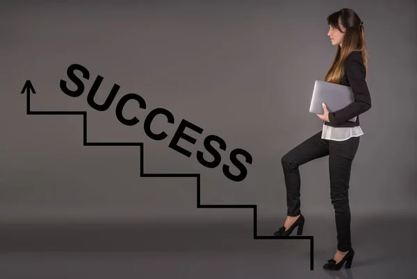 Creative concept about success. Career ladder. Business woman with a laptop