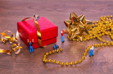 Minyatür insanlar ve bir hediye kutusu ahşap arka plan üzerinde yaratıcı kavramı