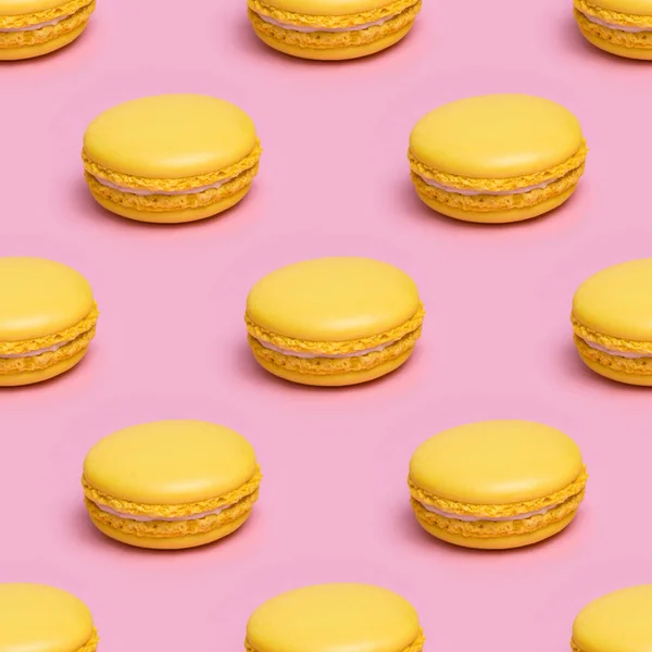 Patrón sin costuras con galletas macaron amarillas sobre un fondo rosa — Foto de Stock