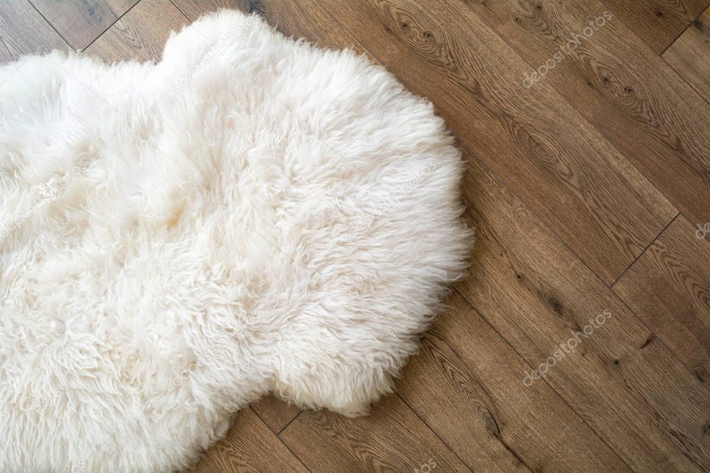 Sheep skin on the laminate floor in the room. View from above