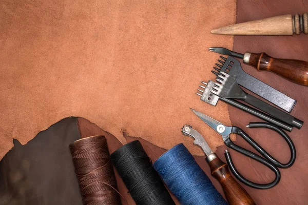 Tools for leather crafting and pieces of brown leather — Stock Photo, Image