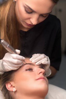 Kalıcı kaş makyajı. Kozmetik uzmanı kaş dövmesi yapıyor.. 