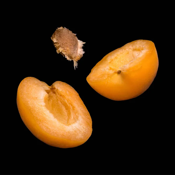 Falling apricots isolated on a black background. Flying fruits in the air.